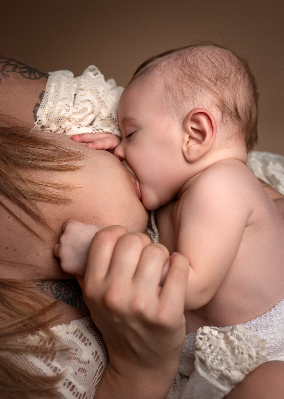 Séance photo bébé éveil en studio avec sa maman. Moment d'allaitement plein de tendresse.