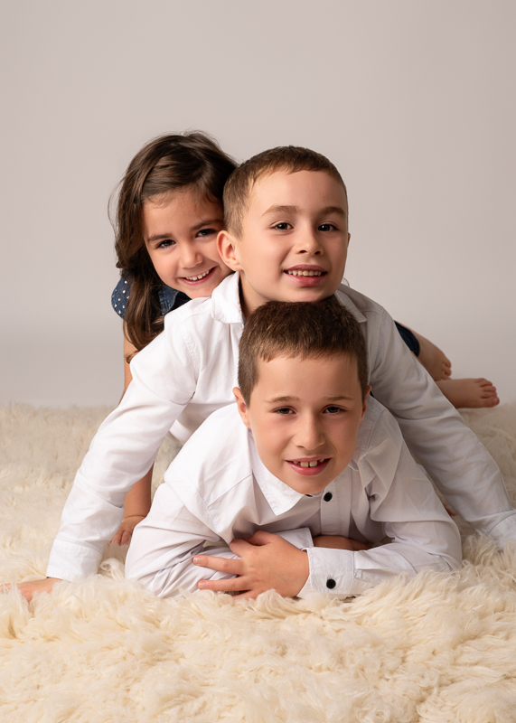 photo-cousins-complicite-enfants-studio Séance photo entre cousins montrant des enfants empilés et rieurs en studio.