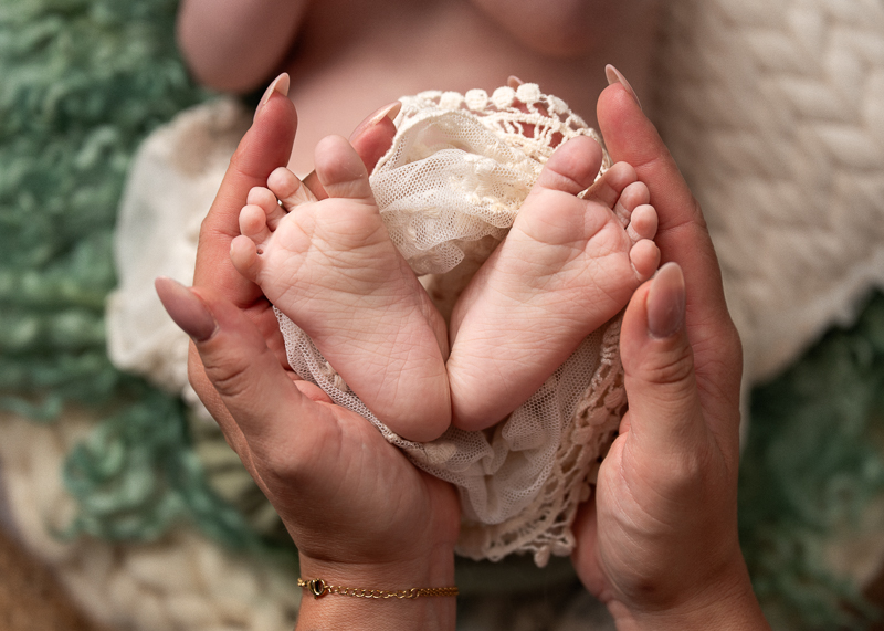 Détail des petits pieds d’un bébé lors d’une séance bébé éveil en studio.