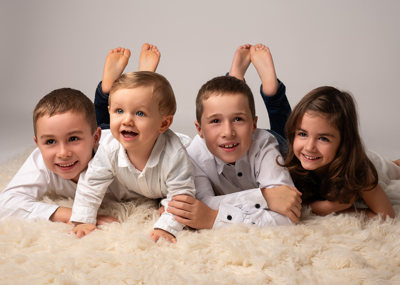 seance-photo-cousins-groupe-enfants-studio Groupe de cousins allongés ensemble lors d’une séance photo en studio.