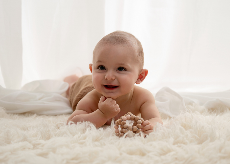 Bébé souriant allongé sur le ventre lors d’une séance photo bébé grandit 6-9 mois près des Sables-d’Olonne en Vendée