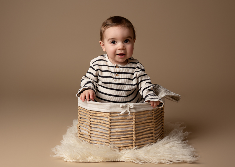 Bébé assis dans un panier lors d’une séance photo bébé en studio à La Roche-sur-Yon en Vendée.