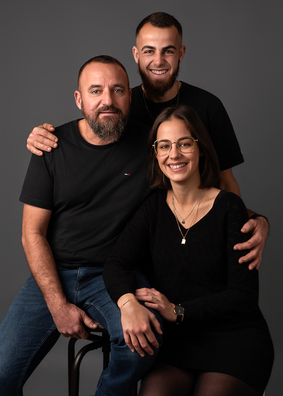 Portrait familial intergénérationnel réalisé en studio Portrait père et enfants adultes lors d’une séance photo famille à Les Clouzeaux.