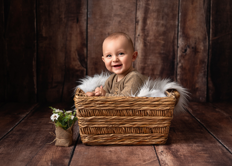 Bébé souriant dans un panier en osier lors d’une séance photo bébé 6-9 mois près des Sables-d’Olonne en Vendée