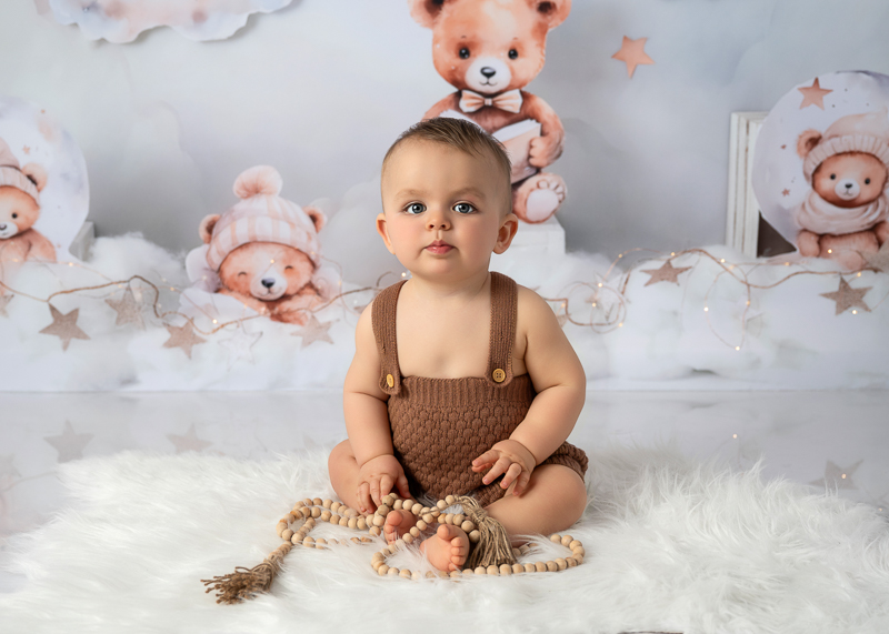 Bébé assis lors d’une séance photo bébé en studio avec décor doux et nuages chez Céline Gardé photographe près de La Roche-sur-Yon en Vendée