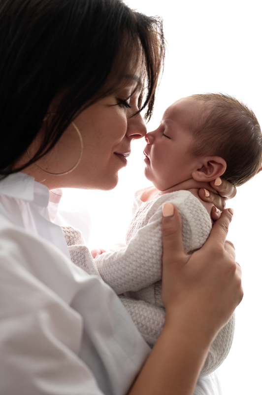 Maman front contre front avec son nouveau-né en contre-jour, séance naissance en studio en Vendée