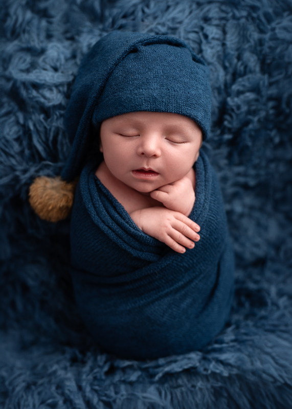 Nouveau-né emmailloté en bleu avec bonnet de nuit à pompon, photographe naissance Aubigny-Les-Clouzeaux