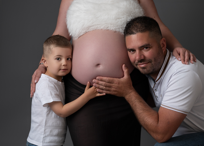 Papa et grand frère entourant le ventre de la future maman, séance grossesse en famille près de La Boissière-des-Landes