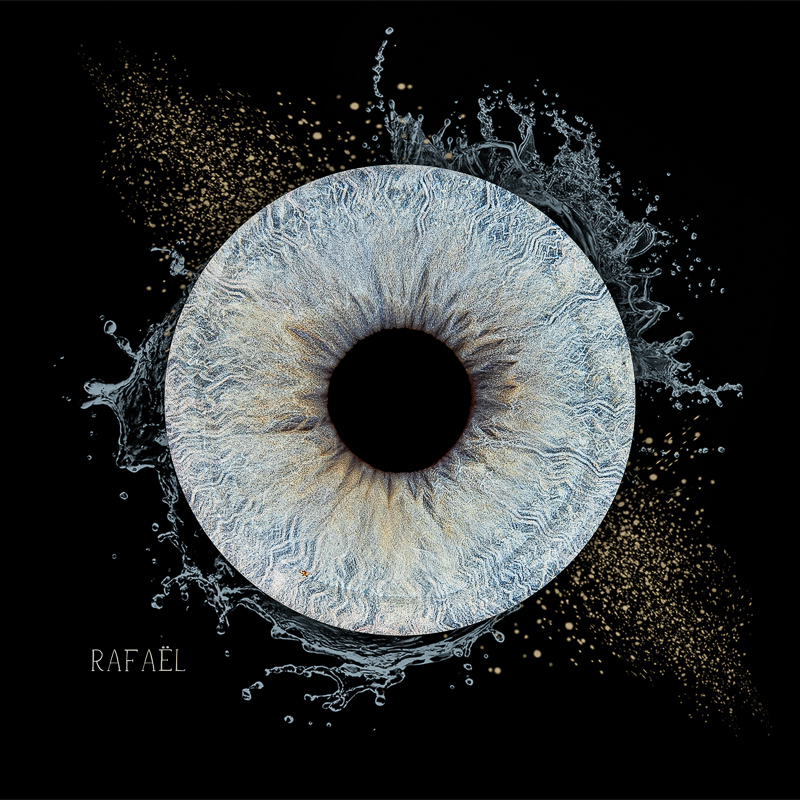 Photo d'iris œil bleu clair — Studio aux Clouzeaux Photo d'iris d'œil gris-bleu avec effet eau et poussière dorée, studio photo en Vendée