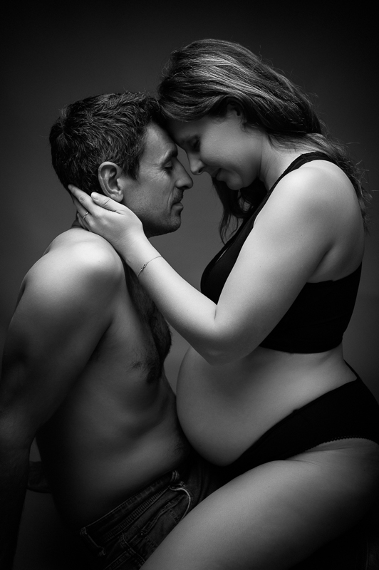 Photo de couple en noir et blanc, future maman et futur papa front contre front, séance grossesse intime près de La Roche-sur-Yon