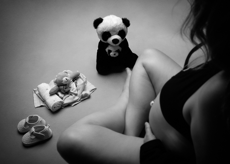 Doudous panda, chaussons de bébé et lange posés au sol à côté du ventre rond de la future maman, photo grossesse noir et blanc, Sainte-Flaive-des-Loups